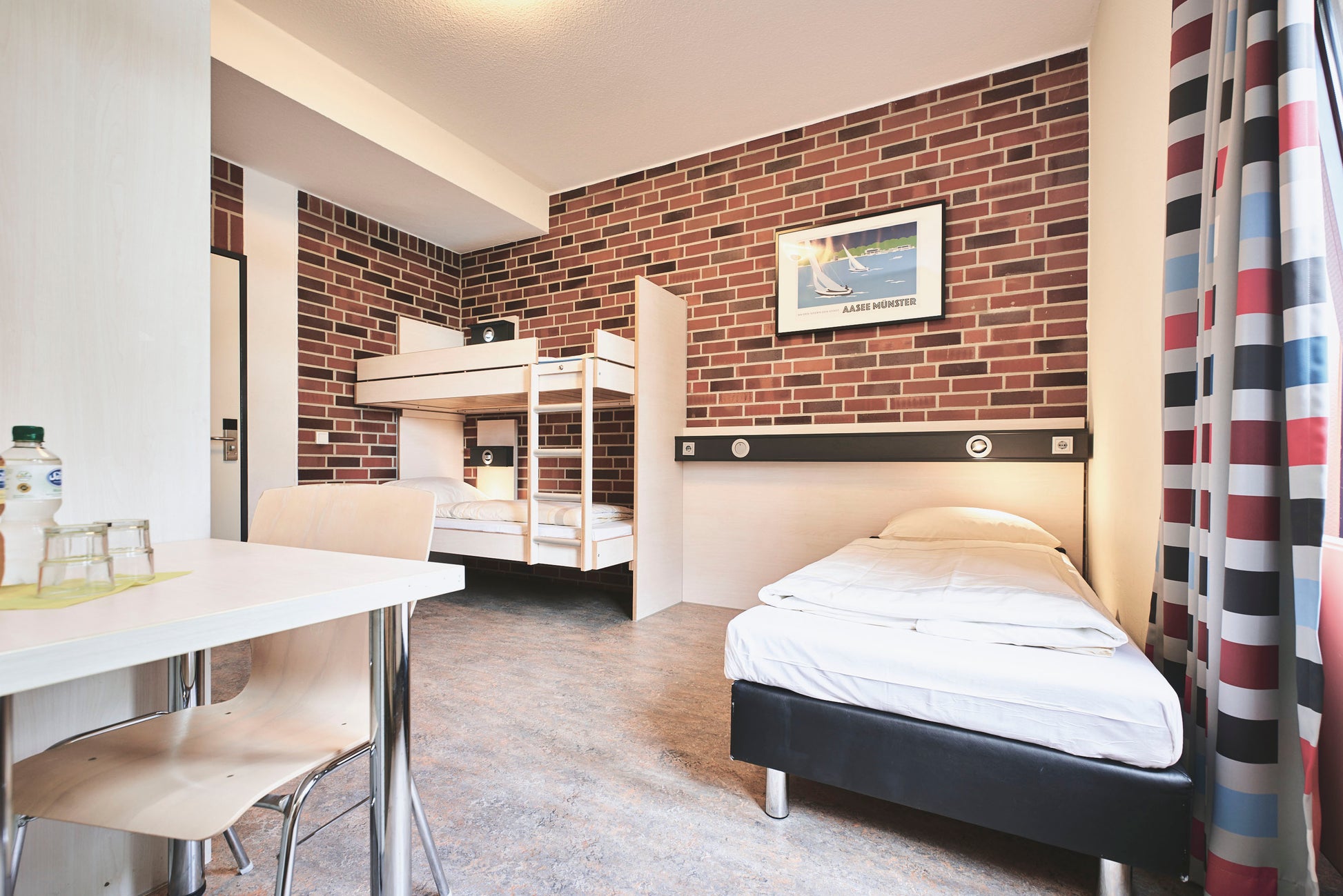 Foto eines schlafzimmers mit einem Einzel und einem Stockbett in der Jugendherberge