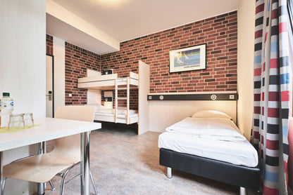 Foto eines schlafzimmers mit einem Einzel und einem Stockbett in der Jugendherberge