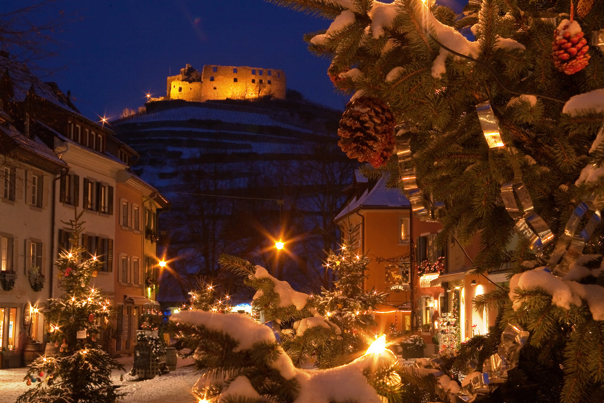 Winterliche Ansicht von Staufen mit geschmückten weihnachtsbäumen und einer beleuchteten Burg